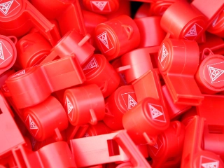 Viele rote Trillerpfeifen mit dem Logo der IG Metall.