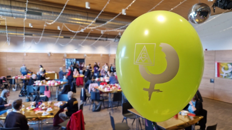 Unser Frauenfrühstück. Blick in den Raum mit einem gelben Ballon im Vordergrund mit einem Aufdruck des Frauenlogos.